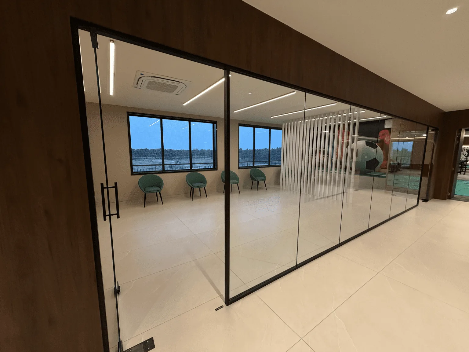 Interior glass partition and door framed in slim black BAARI aluminium profiles